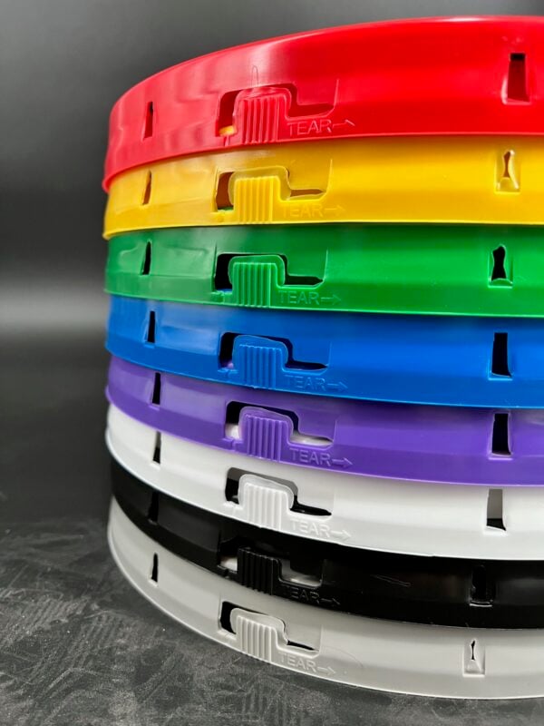 Stack of plastic bucket lids in red, yellow, green, blue, purple, white and black